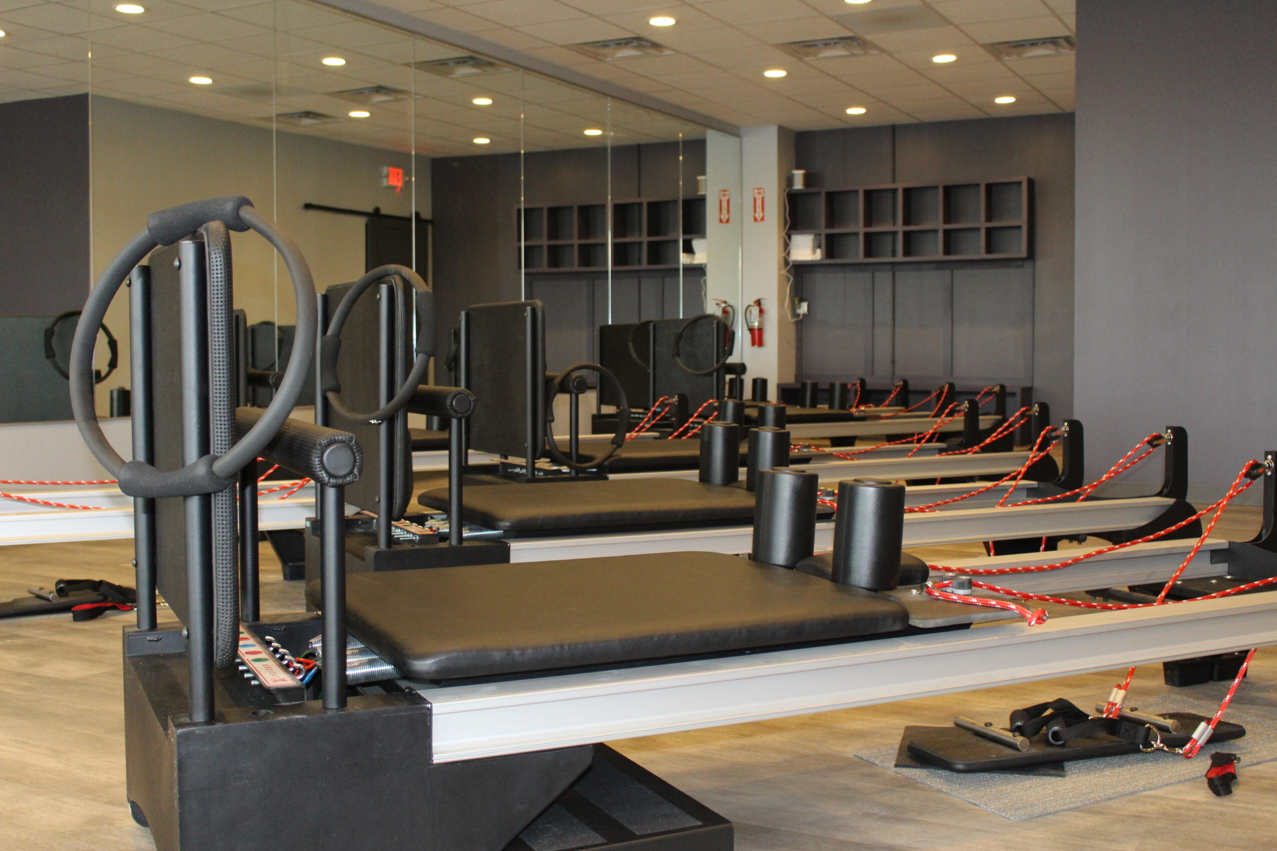 Empty gym with exercise equipment, mirrors, and a padded workout platform in a spacious room.