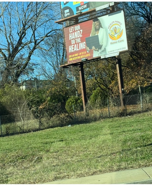 Billboard advertising a healing event, with trees and a grassy area in the background.