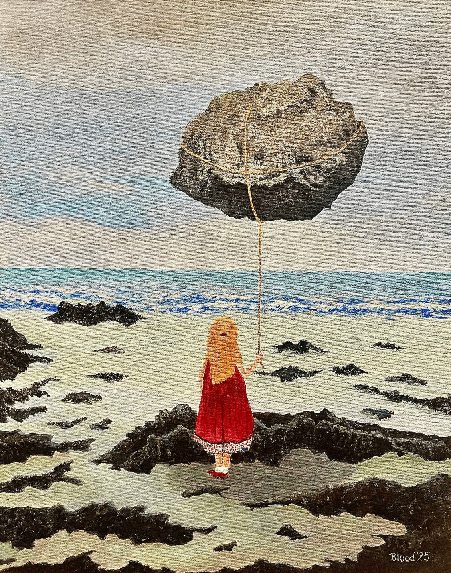 Child in red dress holding a string attached to a large floating rock at the beach.