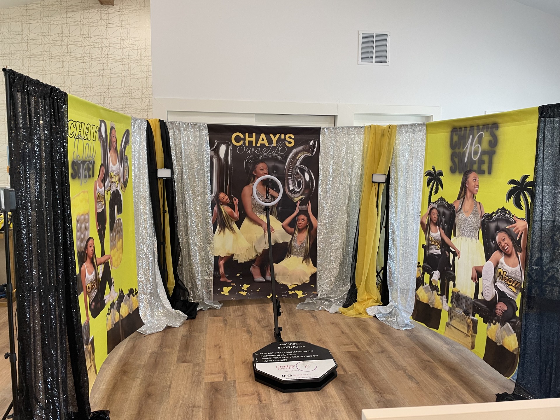 Decorative backdrop with images of a woman playing guitar, yellow and black colors, and palm trees, on a wooden floor.