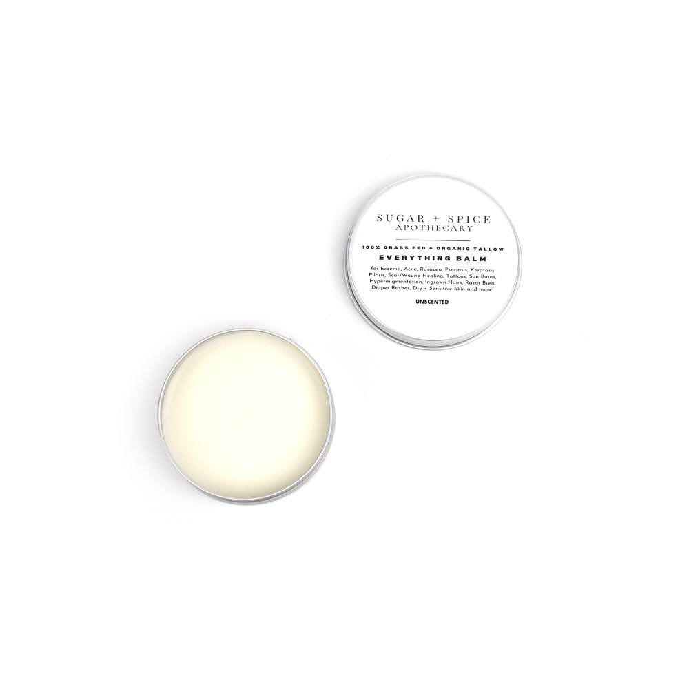 Open container with white balm and lid with text, on a white background.