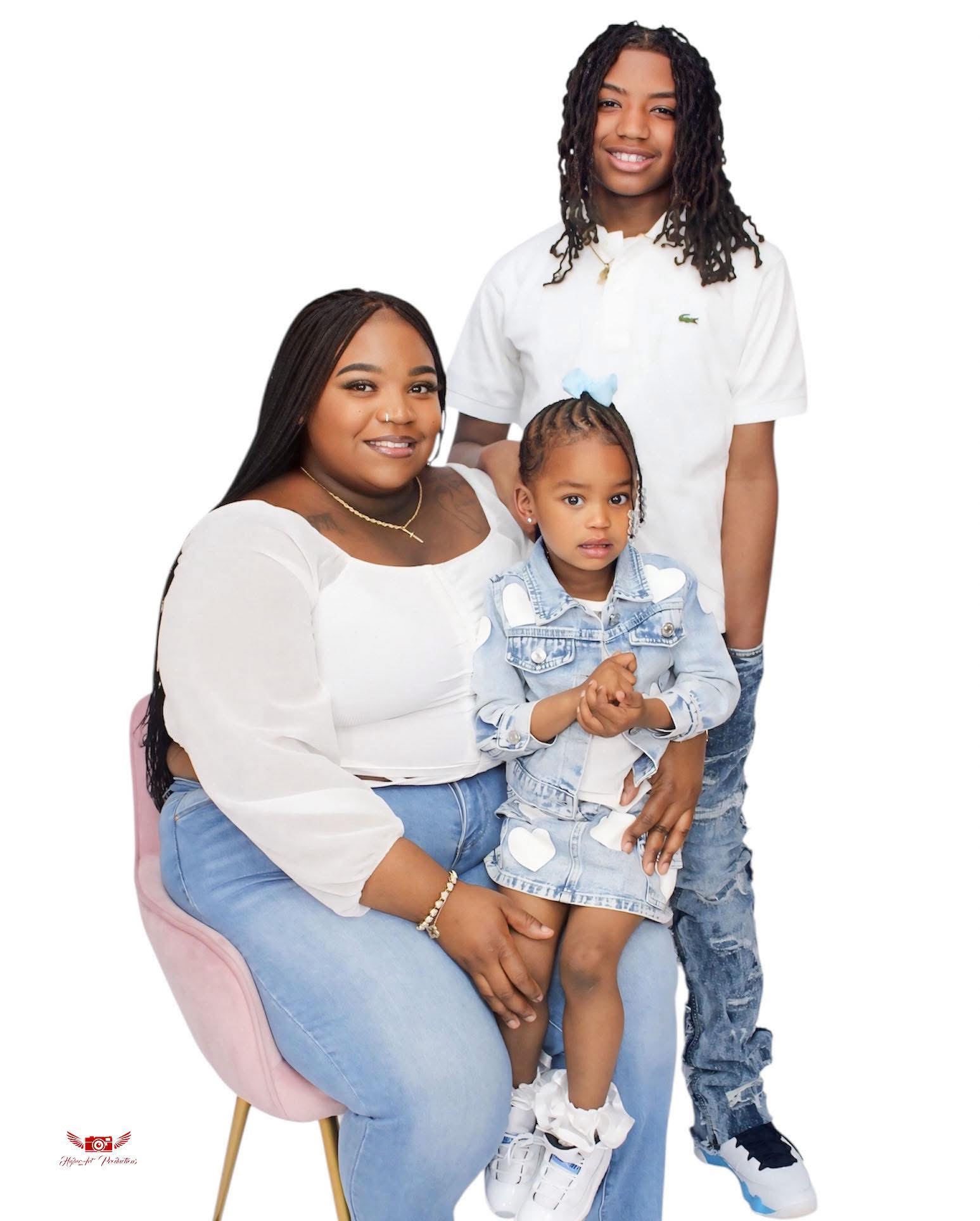 Three people, two women and a girl, pose together smiling against a white background.