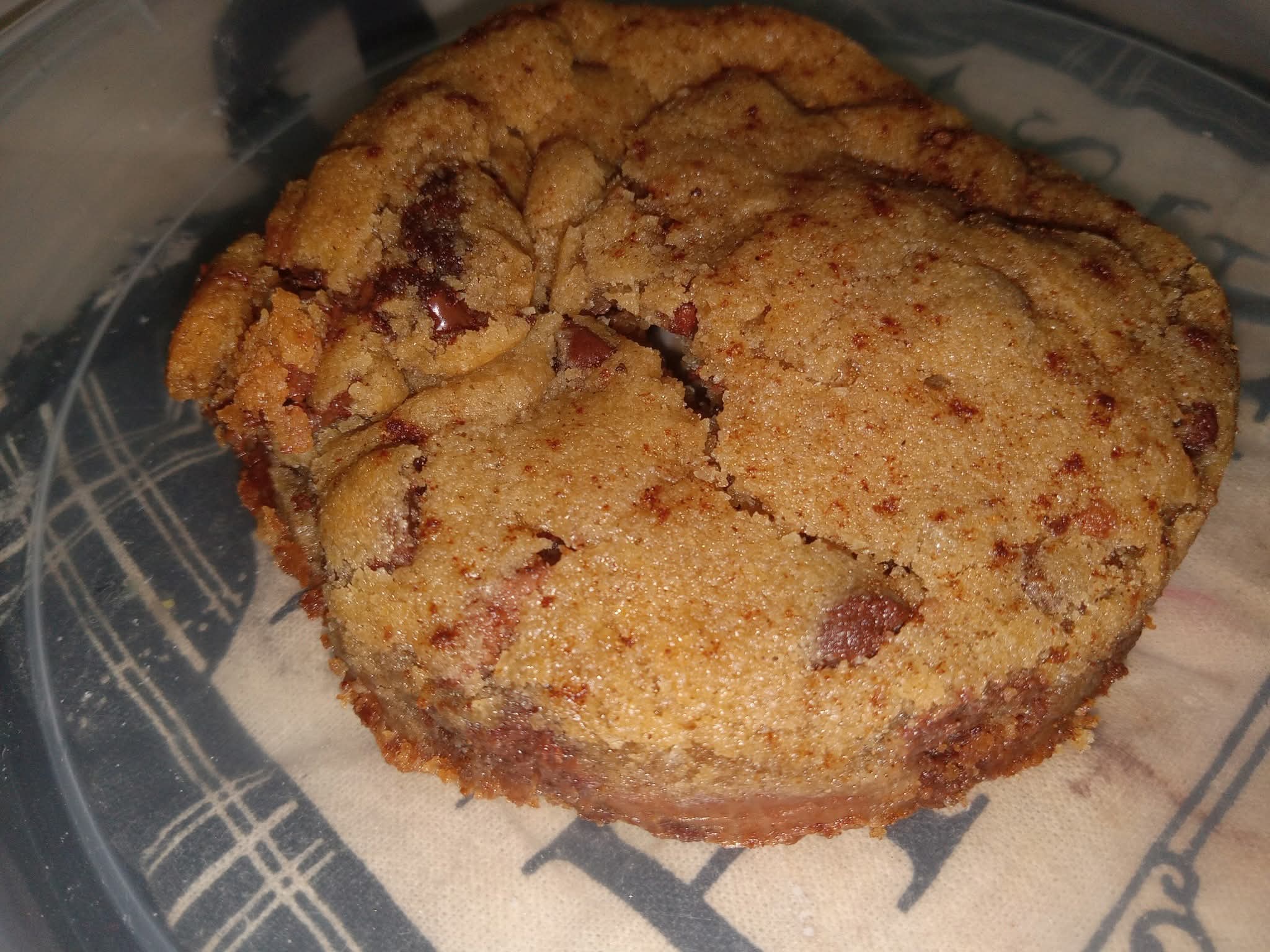 A slice of cake with a crumbly texture and visible fruit pieces on a plate.