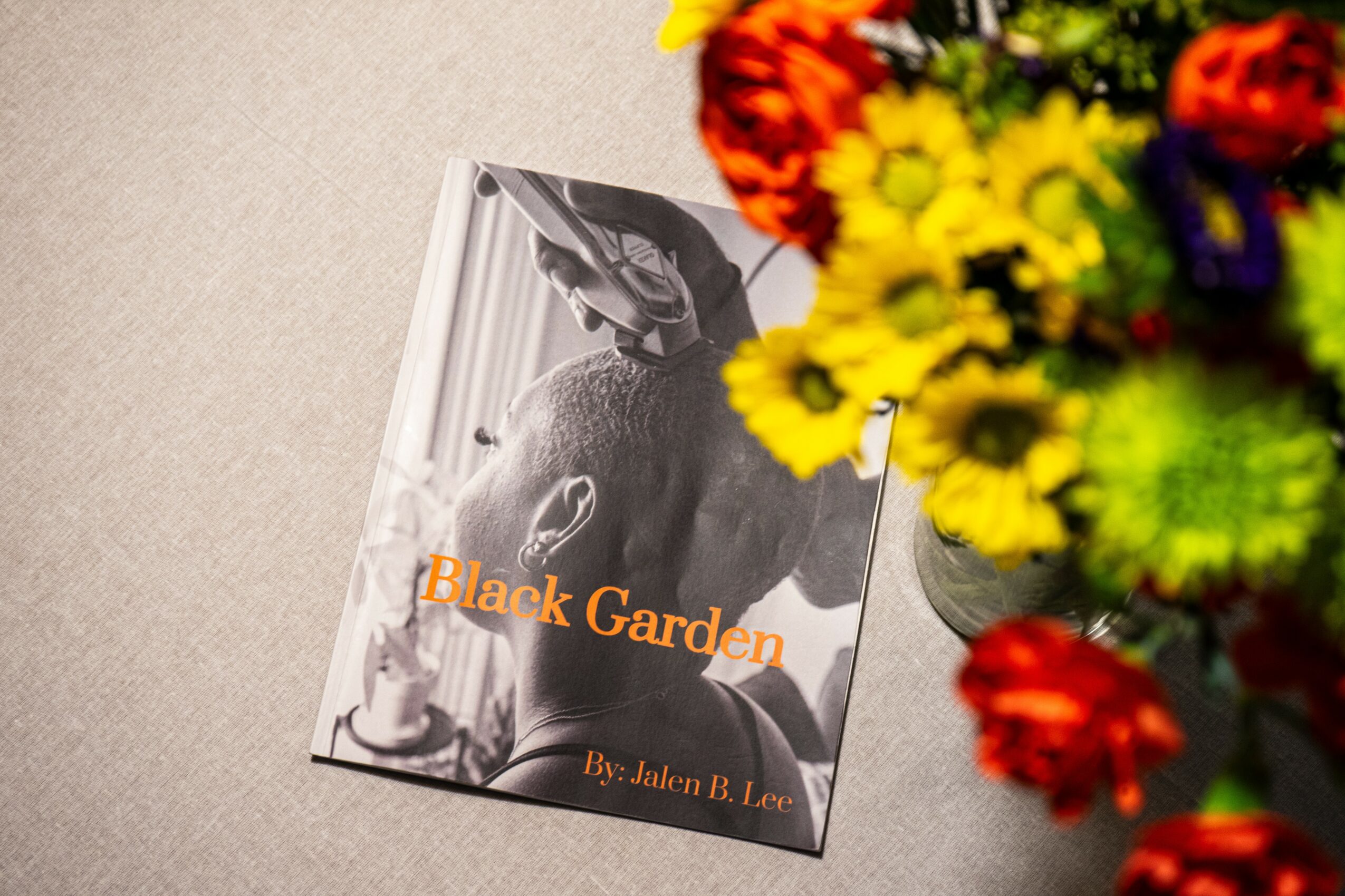 Book titled 'Black Garden' by Jalon B. Lee with a black and white cover image, partially obscured by colorful flowers.