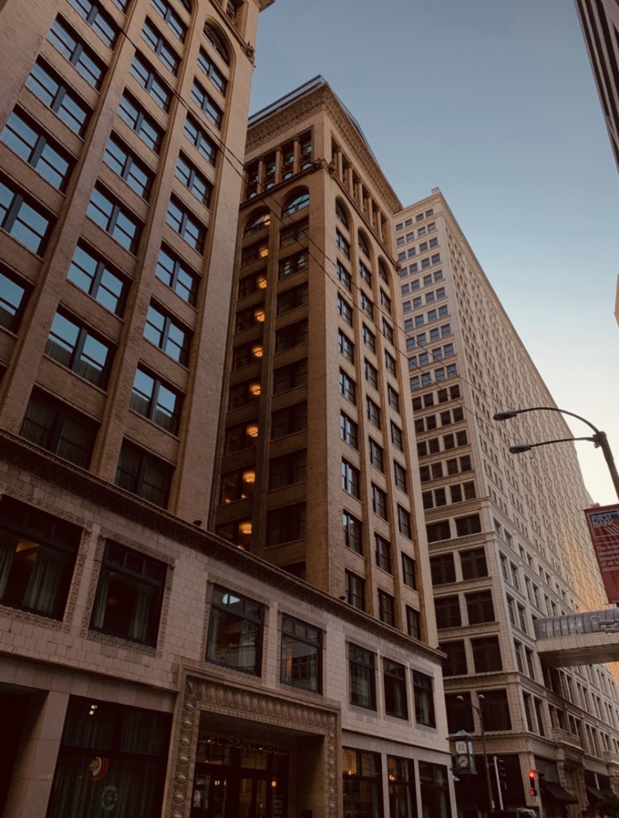 Tall buildings with windows and architectural details against a clear sky, viewed from below.
