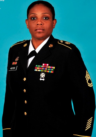Woman in military uniform with medals and insignia, standing against a blue background.