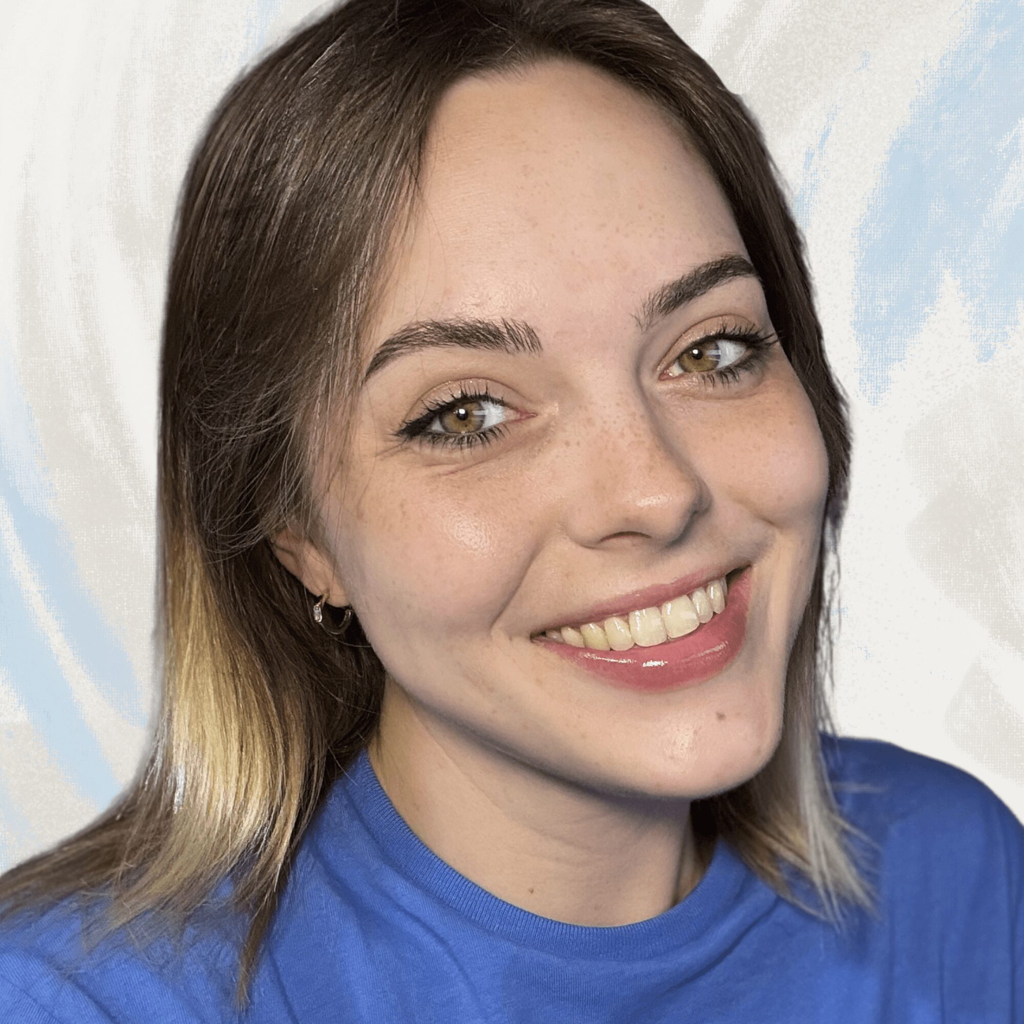 Young woman with shoulder-length hair, smiling, wearing a blue shirt, against a light background.