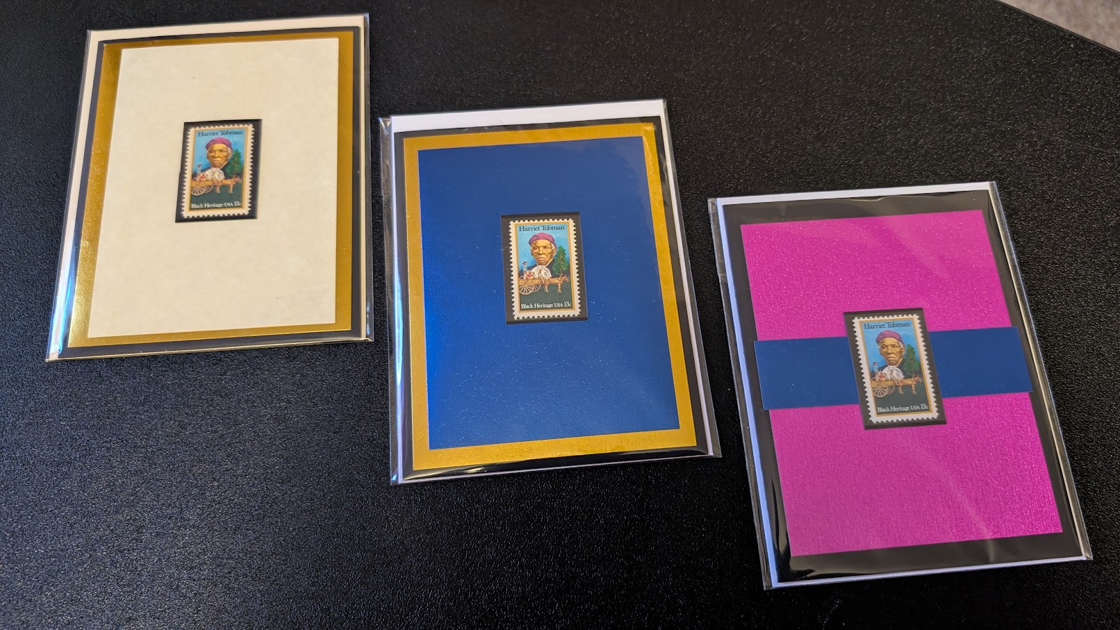 Three framed pictures with colorful backgrounds on a black surface, each featuring a small central image.