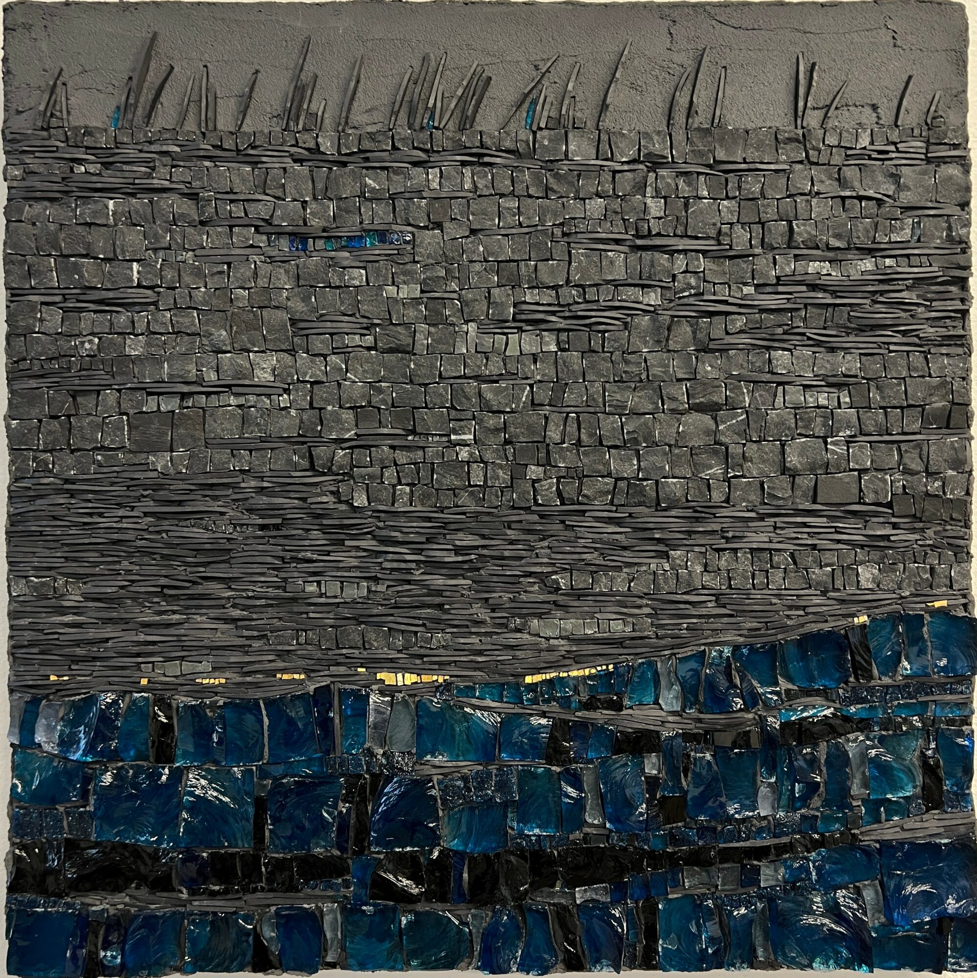 Stone wall with layered stones and a section of blue tiles at the bottom, viewed from below. Word count: 20.