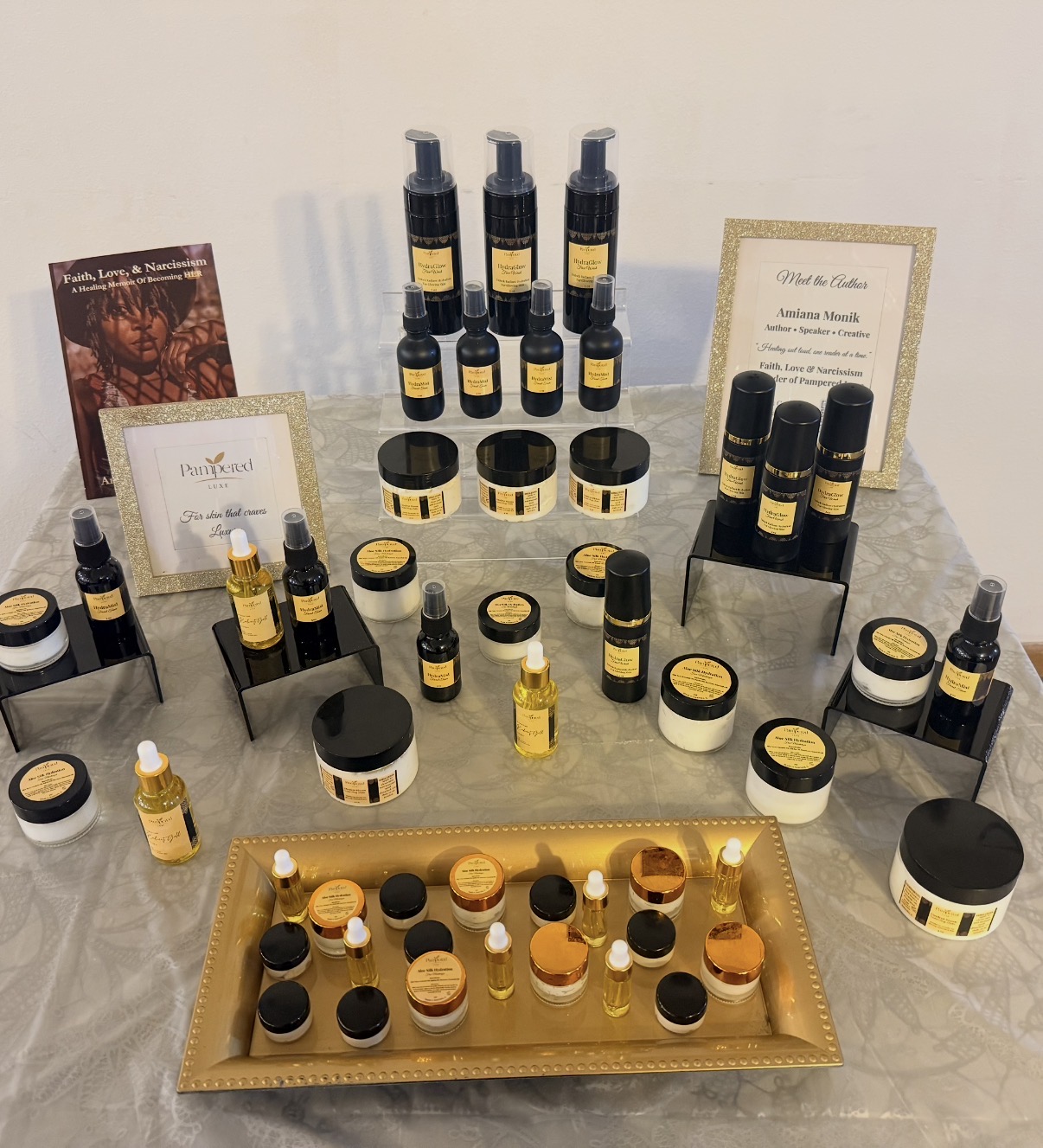 Display of skincare products including bottles, jars, and containers arranged on a table with framed certificates and promotional material.