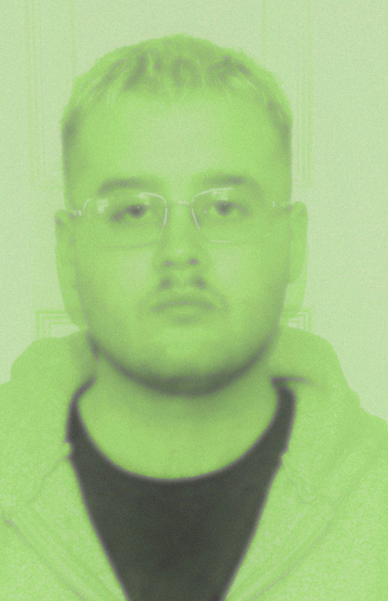 Person with glasses and short hair, facing forward, wearing a hoodie, neutral expression.