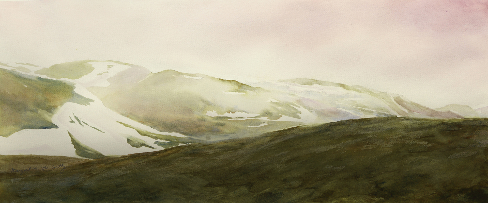 Landscape with snow-capped mountains and green hills under a cloudy sky.