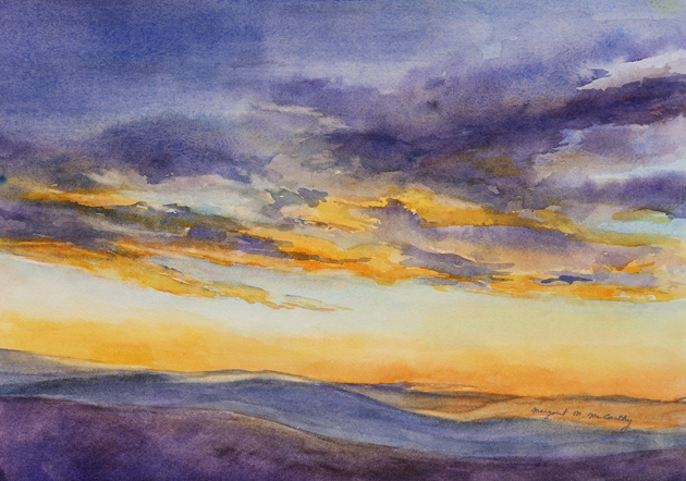 Colorful sky with clouds during sunset over a landscape, with purple, orange, and yellow hues.