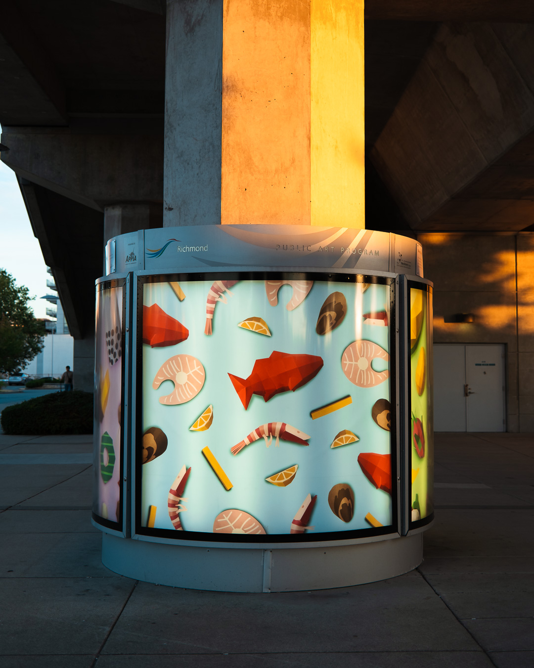 Ice cream-themed display with various ice cream shapes and colors under a bridge, illuminated from within.