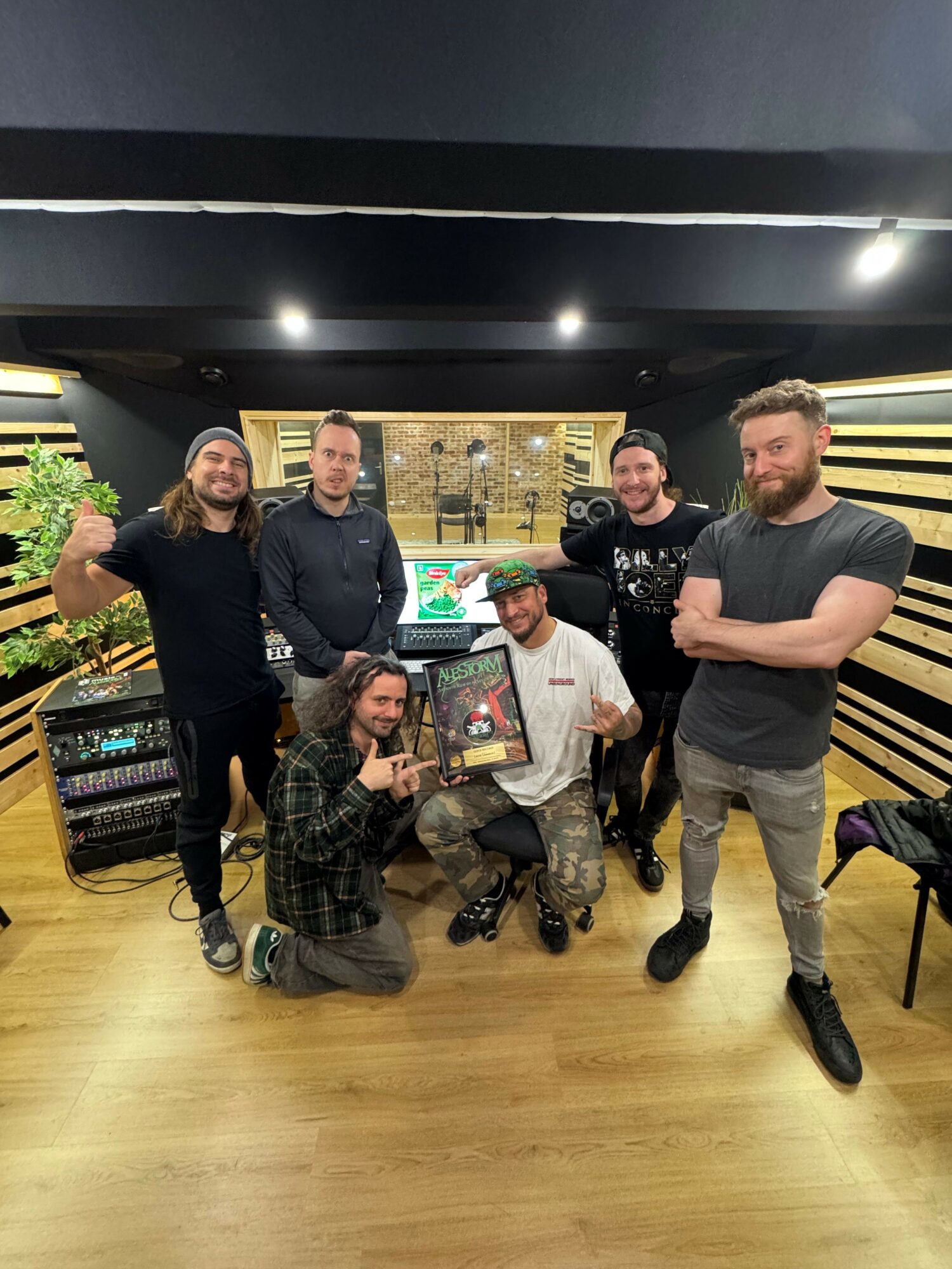 Group of five people in a store, some standing and some sitting, with shelves and products in the background.
