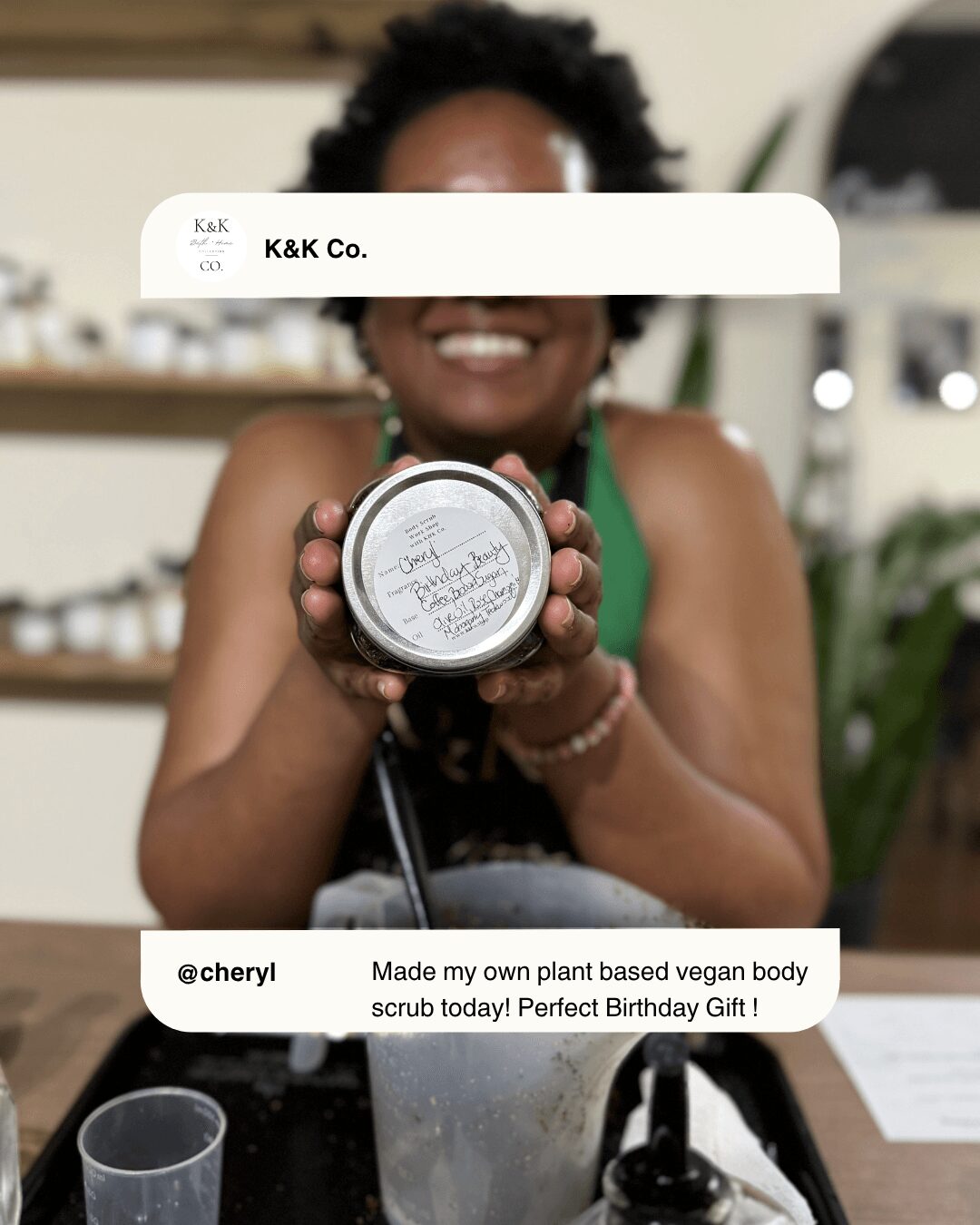Person smiling holding a round container, with text about a vegan body scrub gift, in a room with shelves and plants.