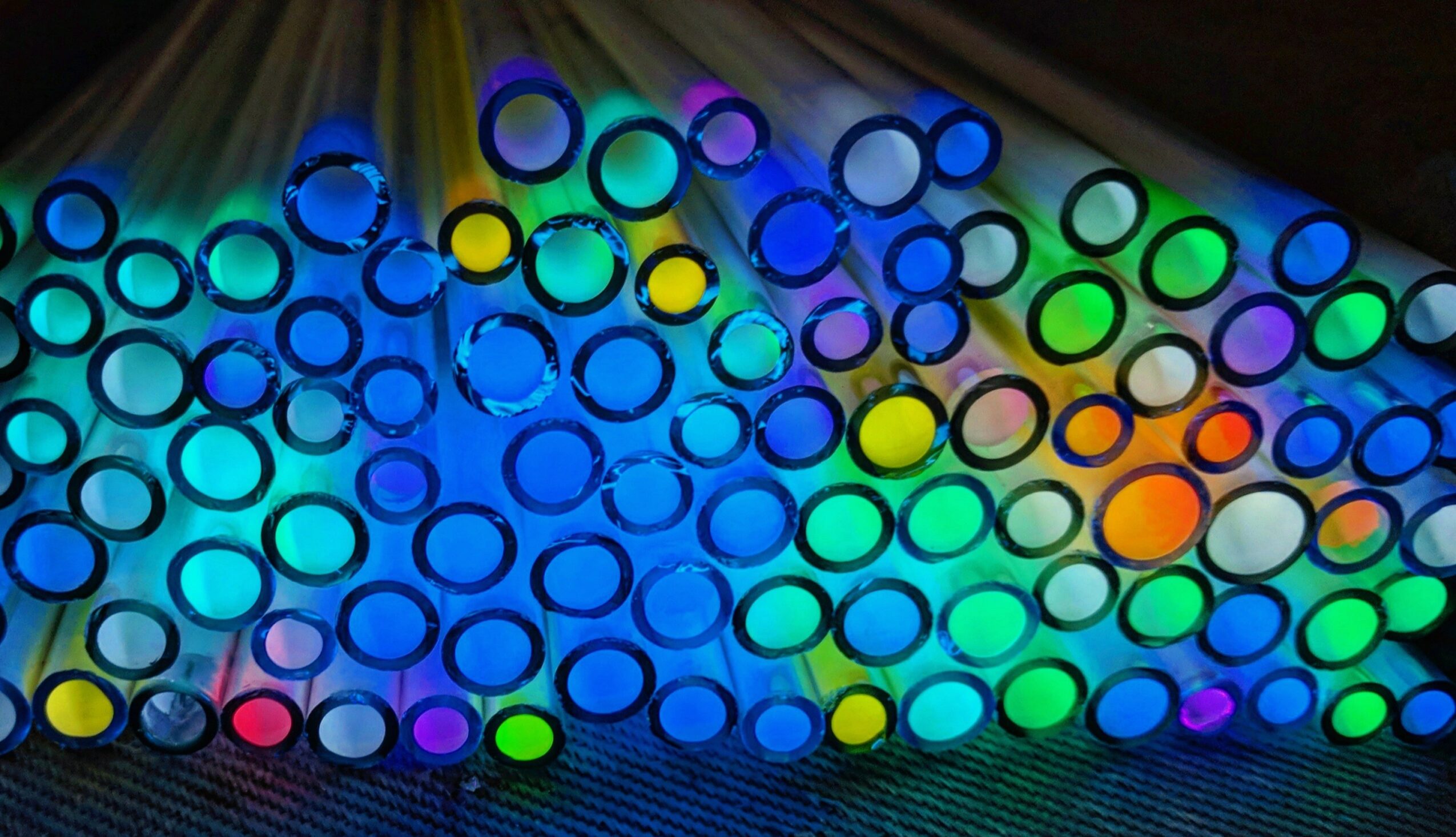 Colorful glow sticks arranged in rows with vibrant, glowing colors and patterns.