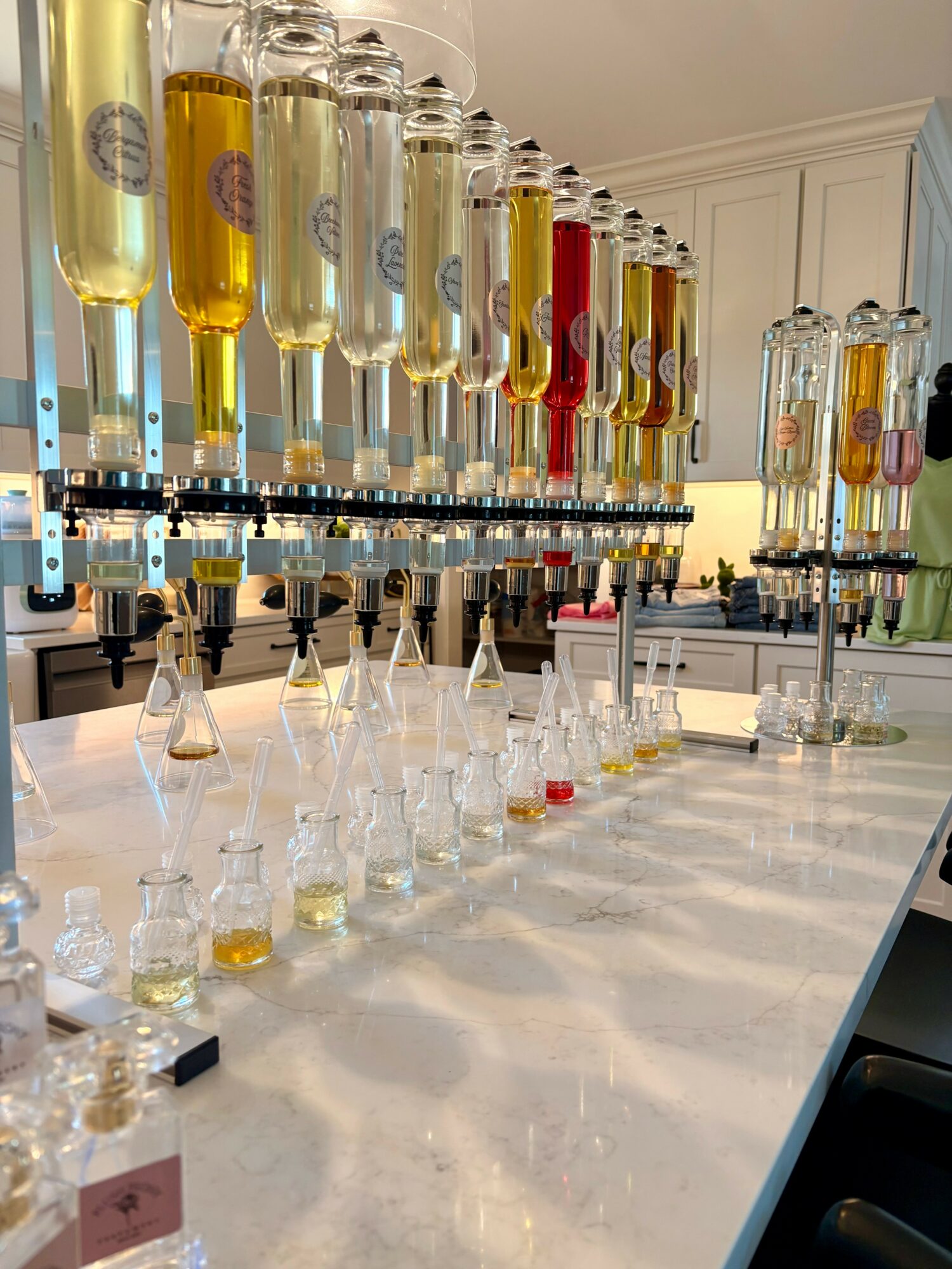 Laboratory setup with glass bottles and test tubes on a white countertop in a bright room.