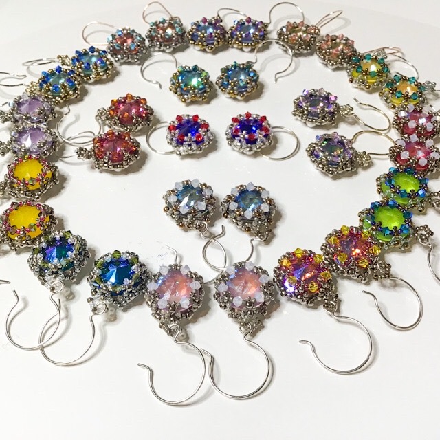 Colorful beaded earrings arranged in a circle on a white surface, with various colors and designs.