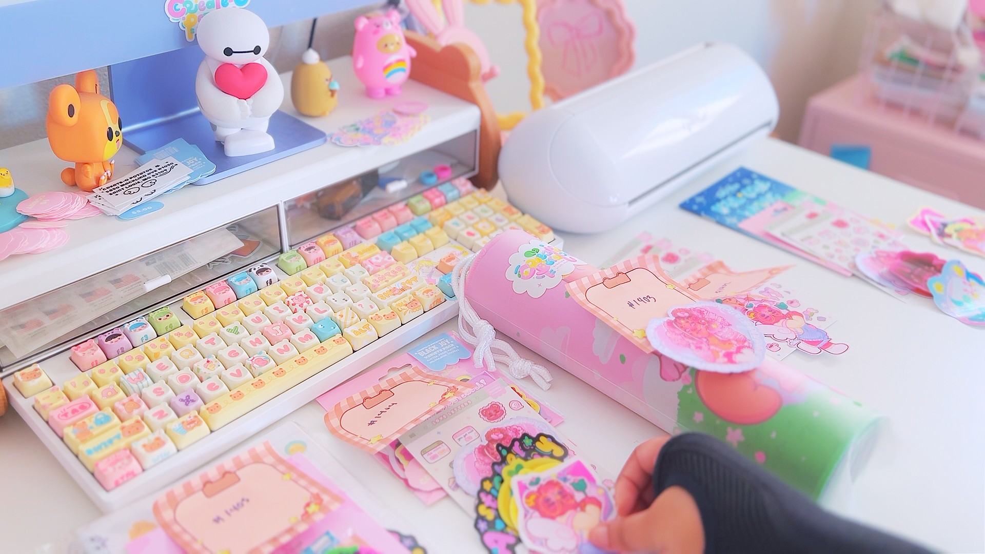 Colorful toy and stationery items on a desk, including a keyboard, plush toys, and decorative accessories.