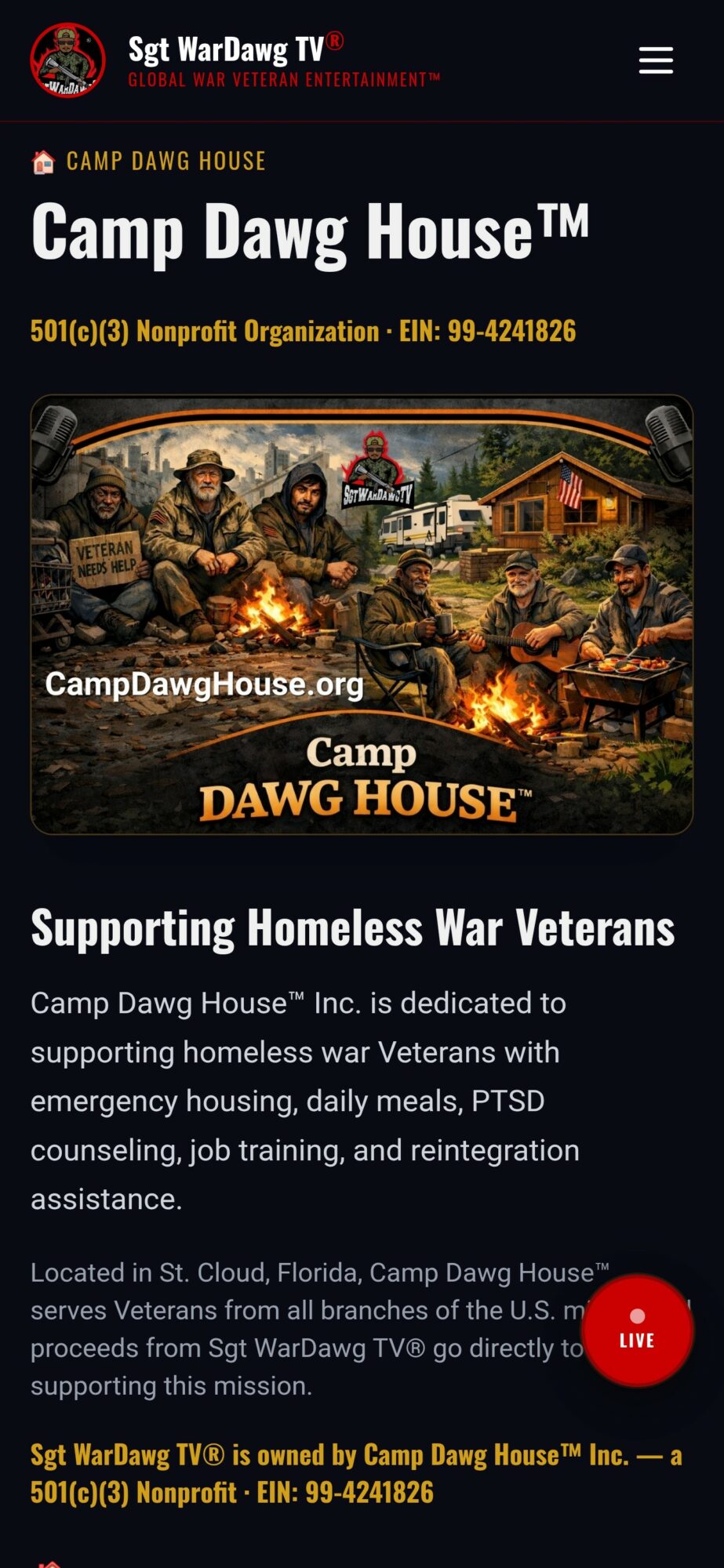Group of people in military uniforms sitting around a campfire outside a cabin, with trees and a building in the background.