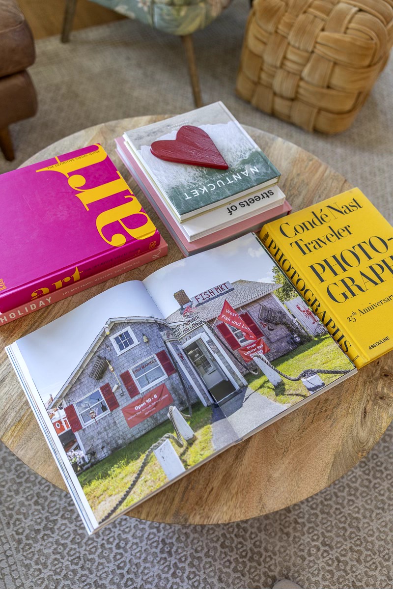 Open magazine showing a house with a red and white exterior, surrounded by a lawn and trees.