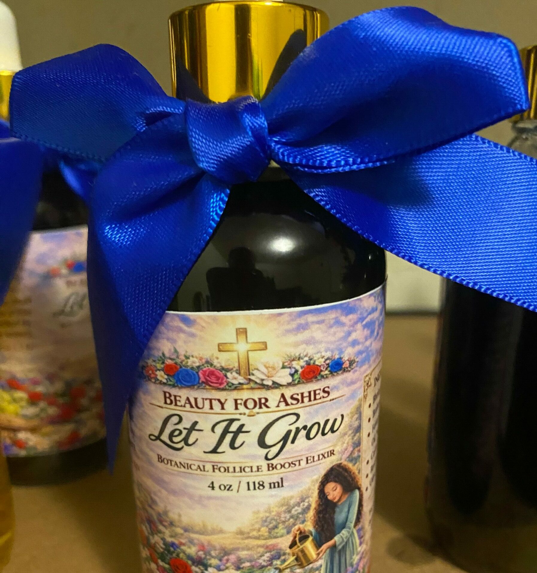 Bottle with a blue ribbon bow, label with colorful design, placed on a brown surface.