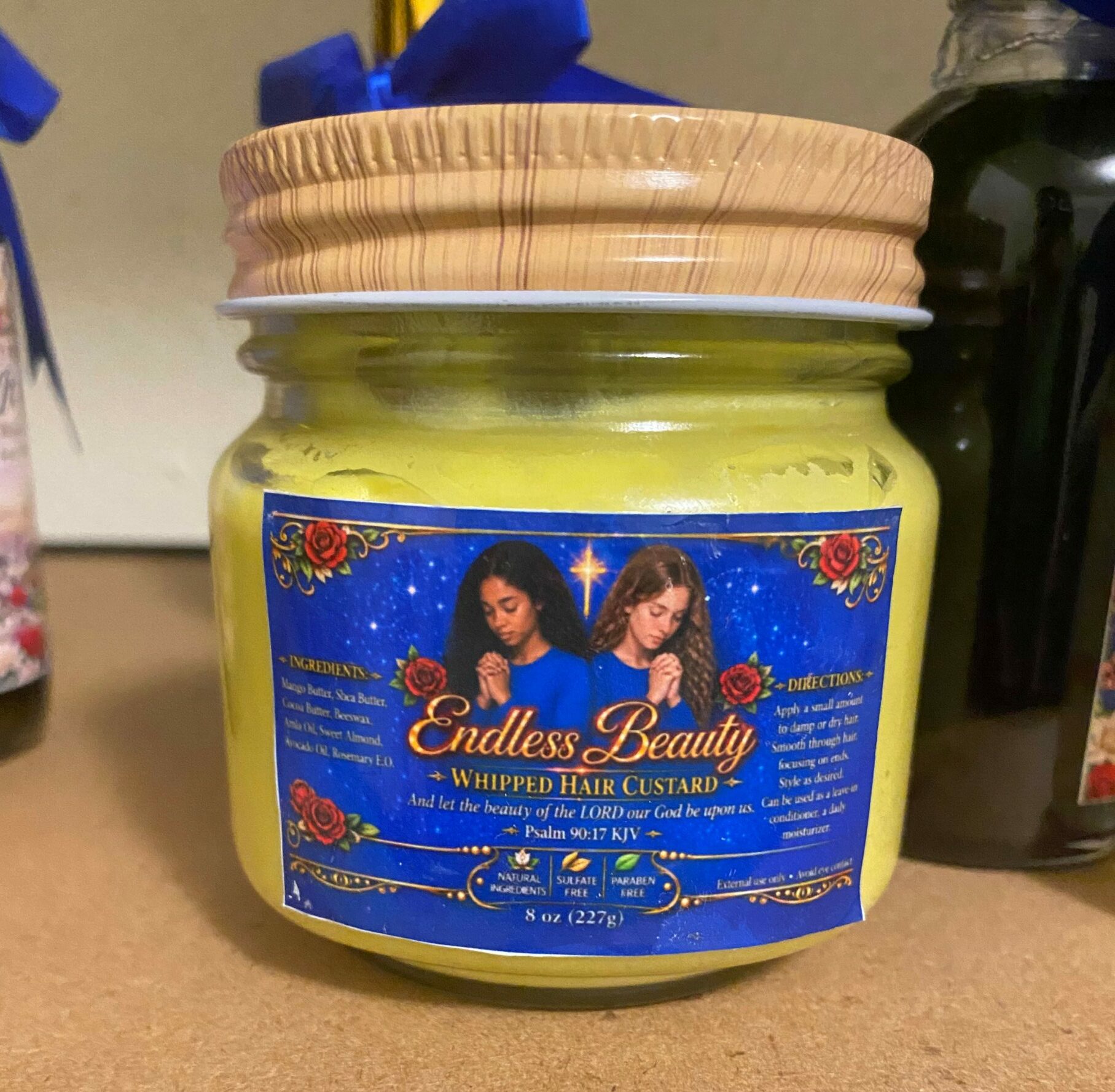 Jar of Elmer's Super Glue with a blue label featuring two women, on a beige surface.