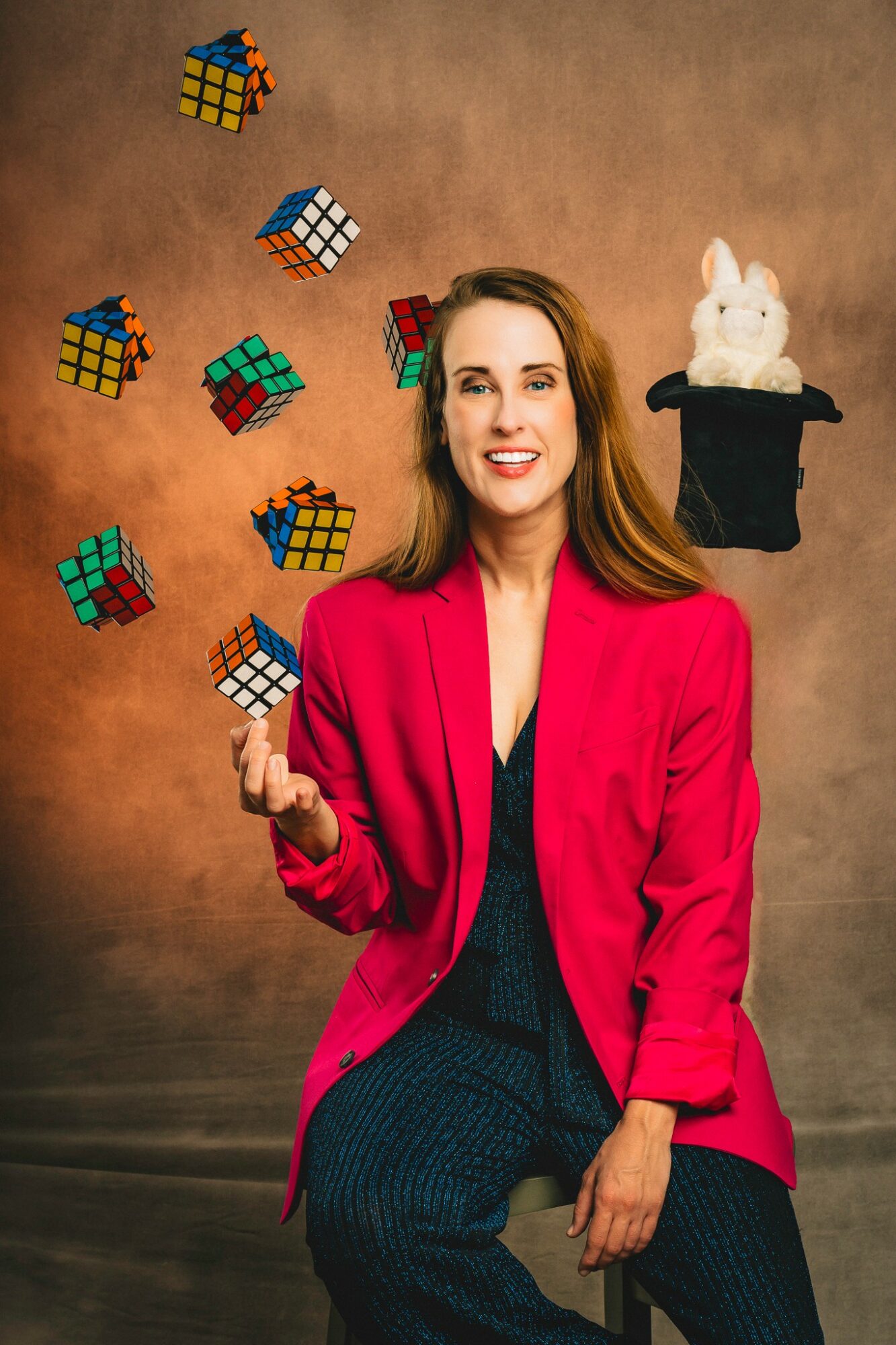 Woman in red blazer juggling Rubik's cubes with a white rabbit in a hat floating nearby, brown background.