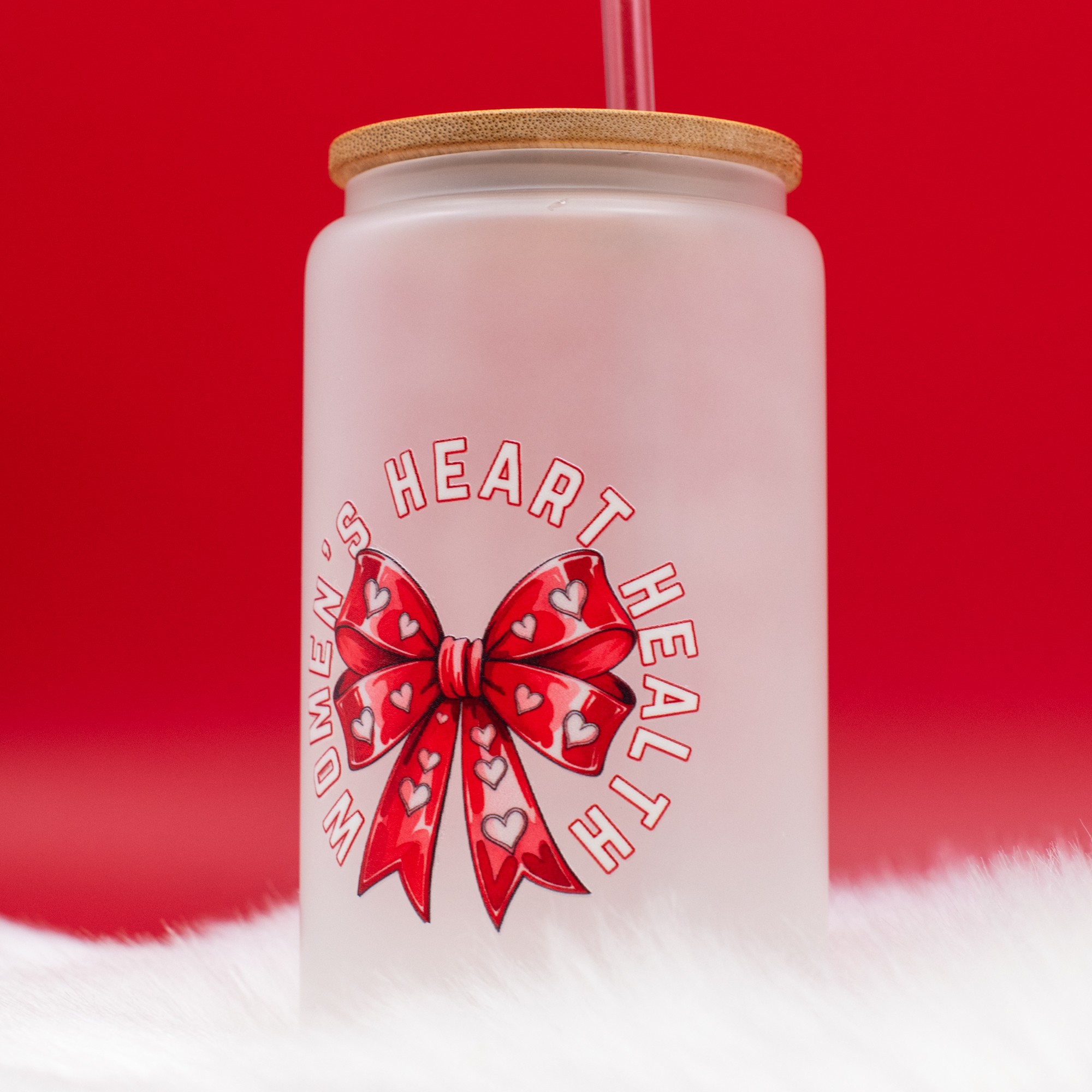 White jar with a red bow design and the words 'HEART HEAL' on a red background, with a white furry surface at the bottom.