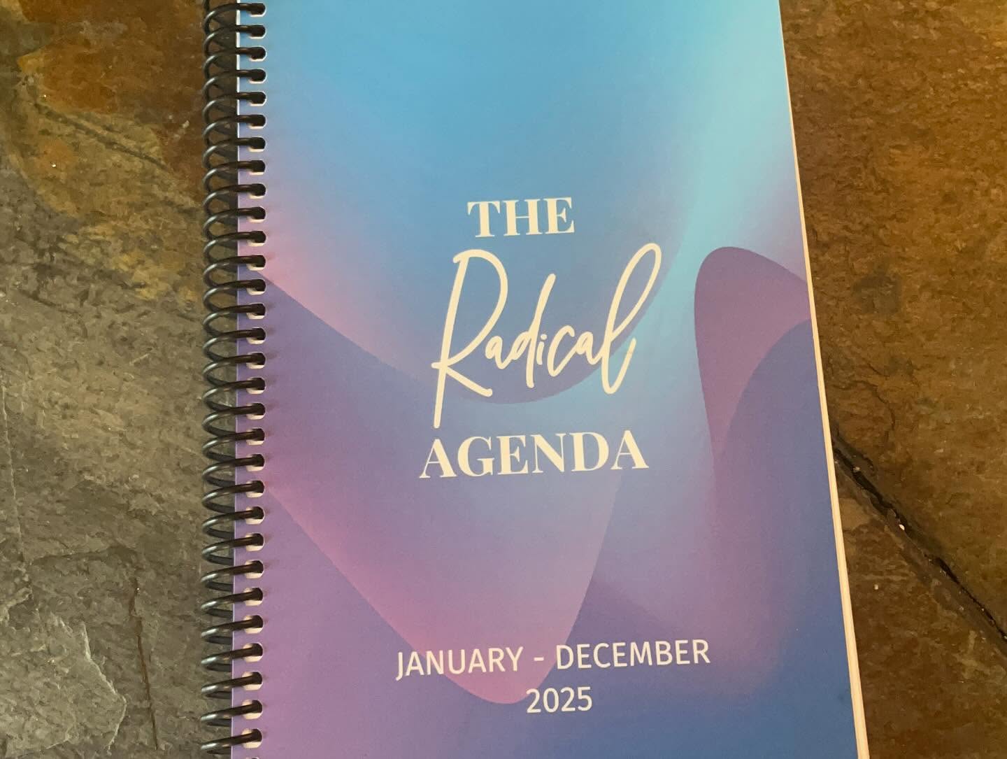 Cover of a planner titled 'The Radical Agenda' for January to December 2025, with a blue and purple gradient background.