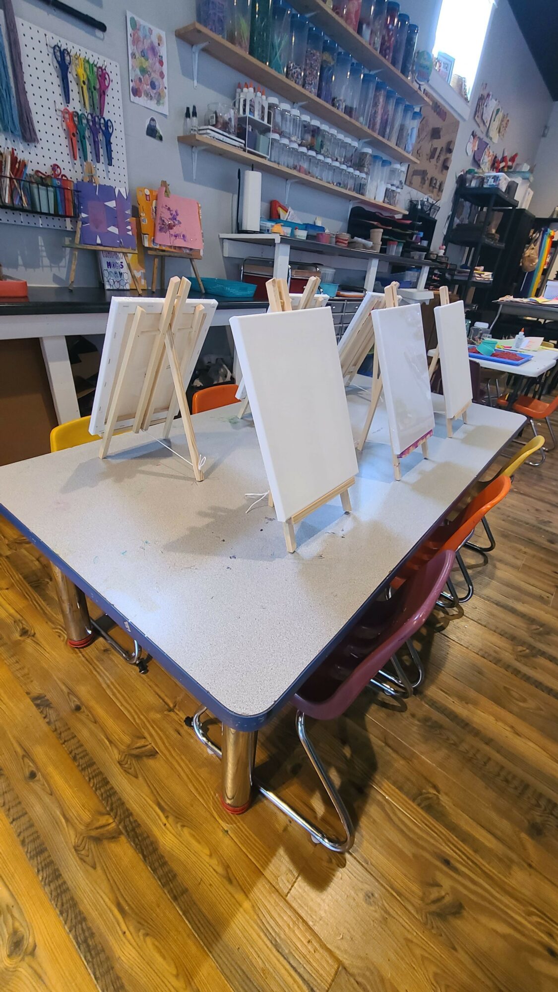 A table with white paper bags and a glass of water in a store or cafe setting.