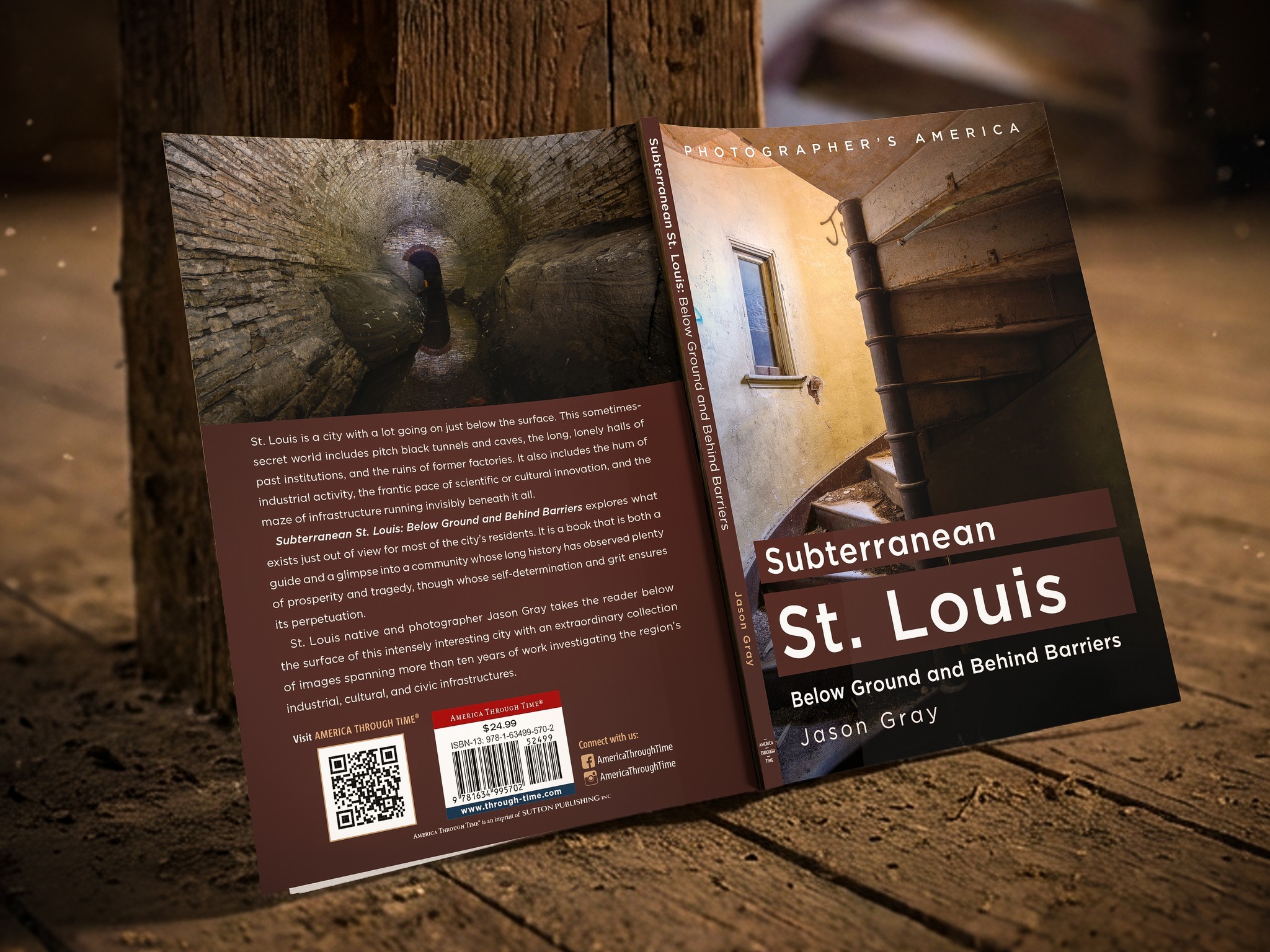 Open book about subterranean St. Louis with a photo of a tunnel entrance and a building wall, on a wooden surface.