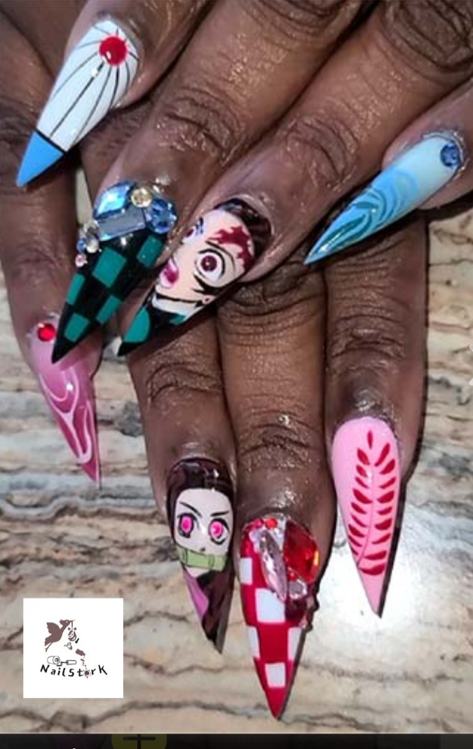 Close-up of decorated fingernails with various colorful designs and embellishments, including checkered patterns, swirls, and floral motifs.