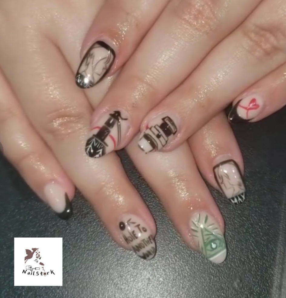 Close-up of hands with decorated nails featuring various designs including hearts, text, and abstract patterns.