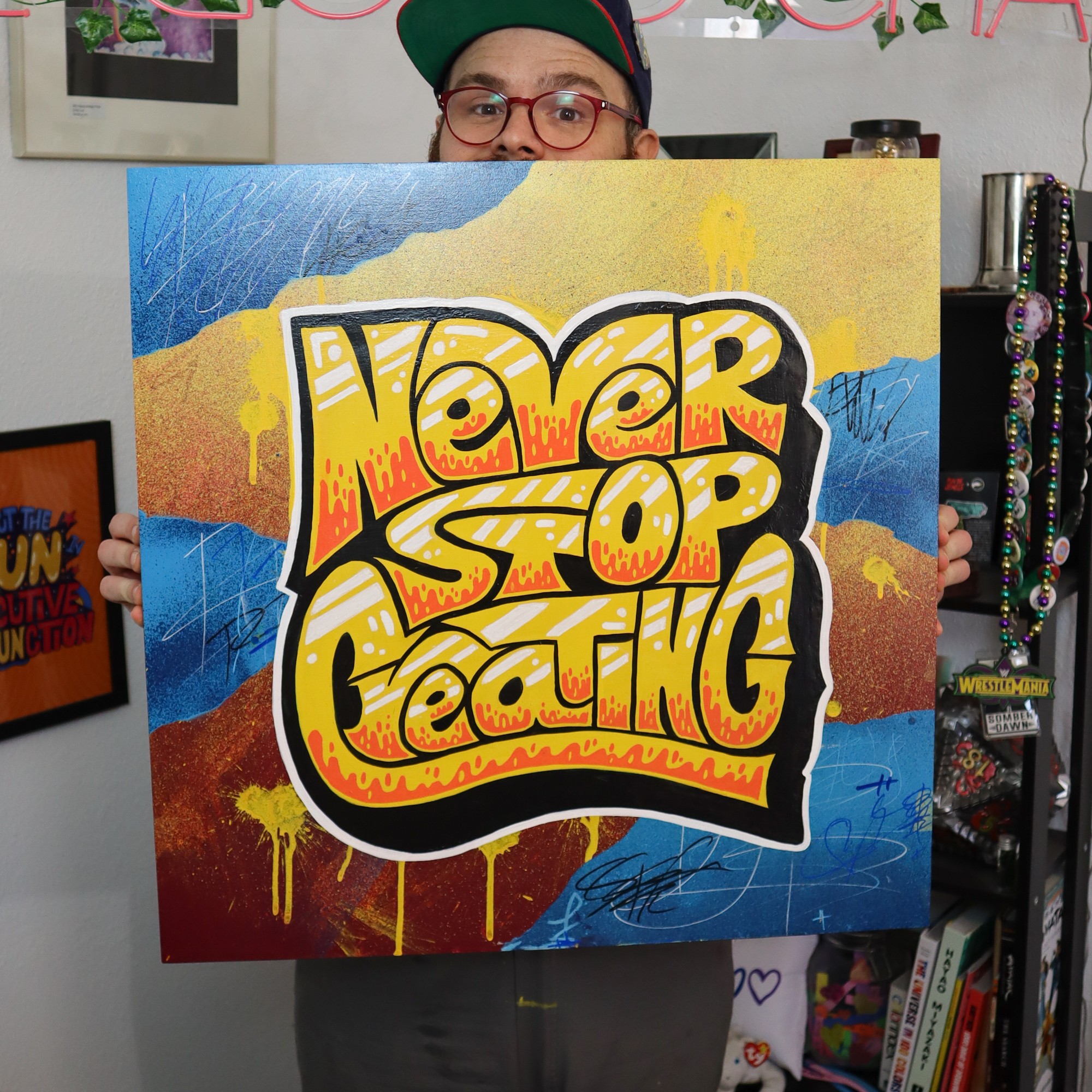 Person holding a colorful sign with the words 'Hater Stop Eating' in graffiti style.