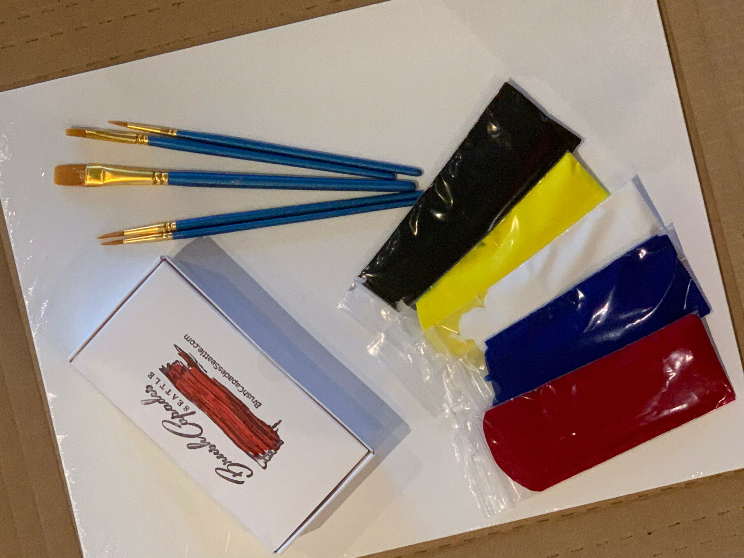 Pens, colored pouches, and a card on a white surface.