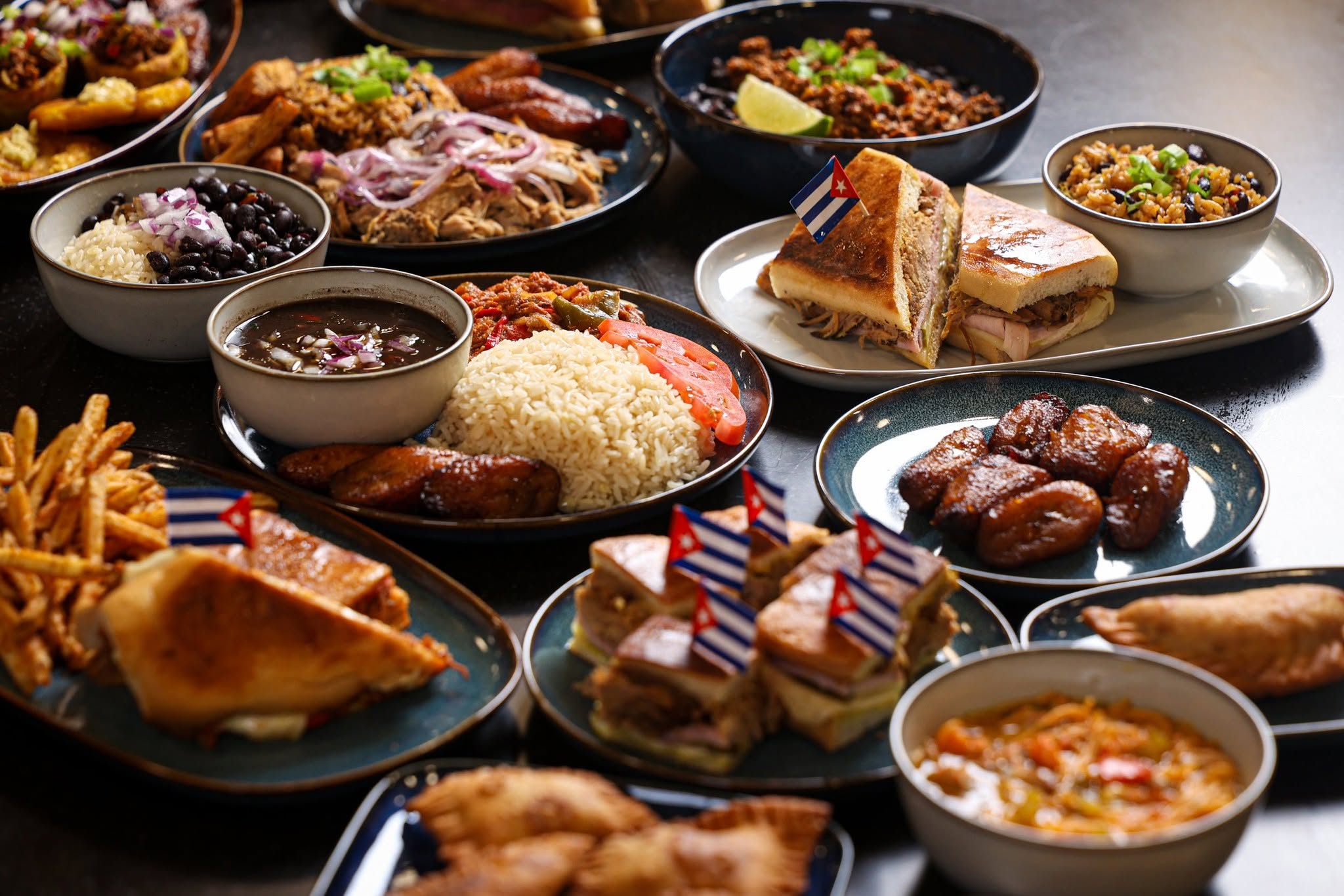 Assorted dishes including fried chicken, rice, desserts, and side dishes on a table, with small American flags on some desserts.