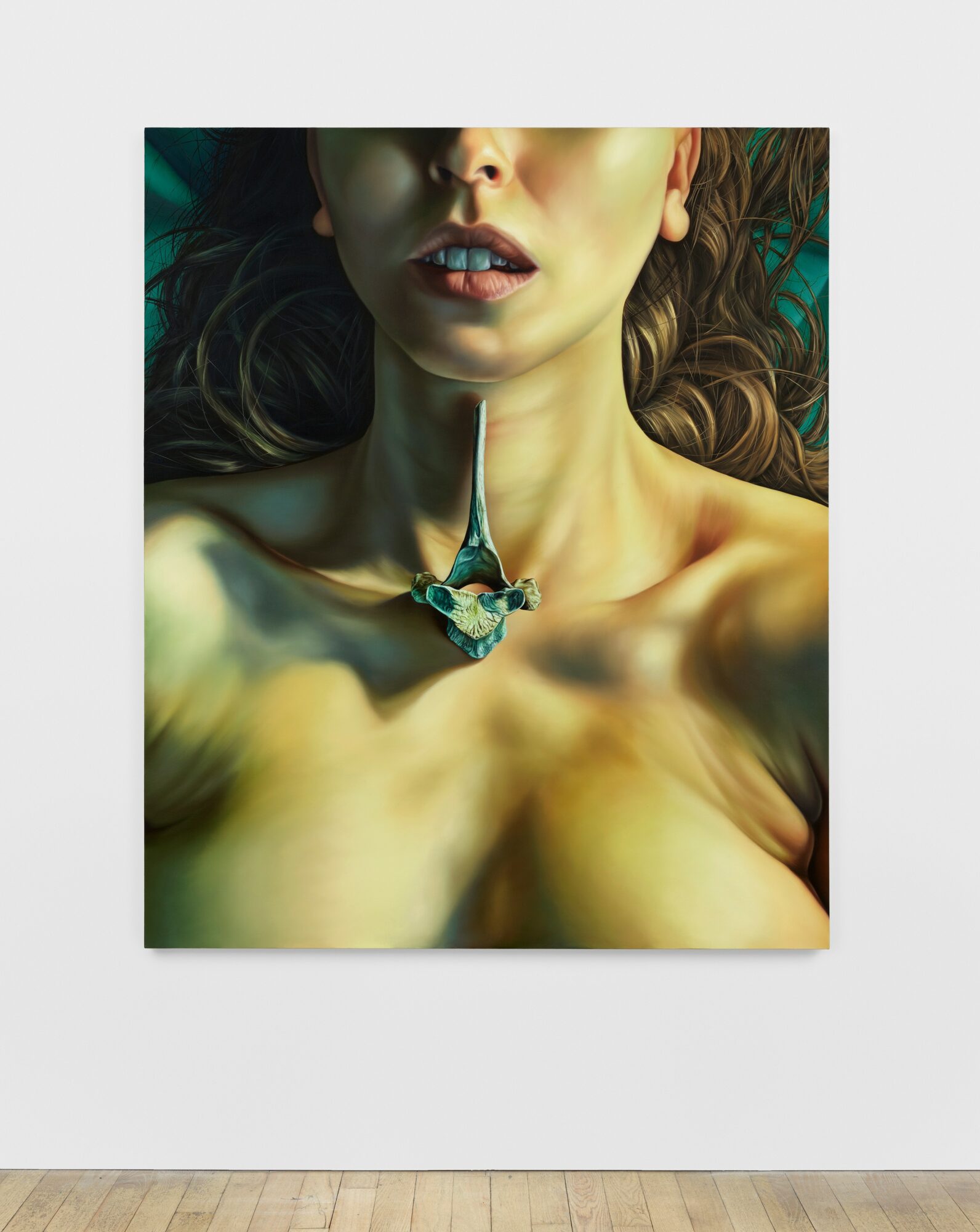 Close-up of a woman with wavy hair, wearing a necklace, with her shoulders exposed, looking slightly upward.