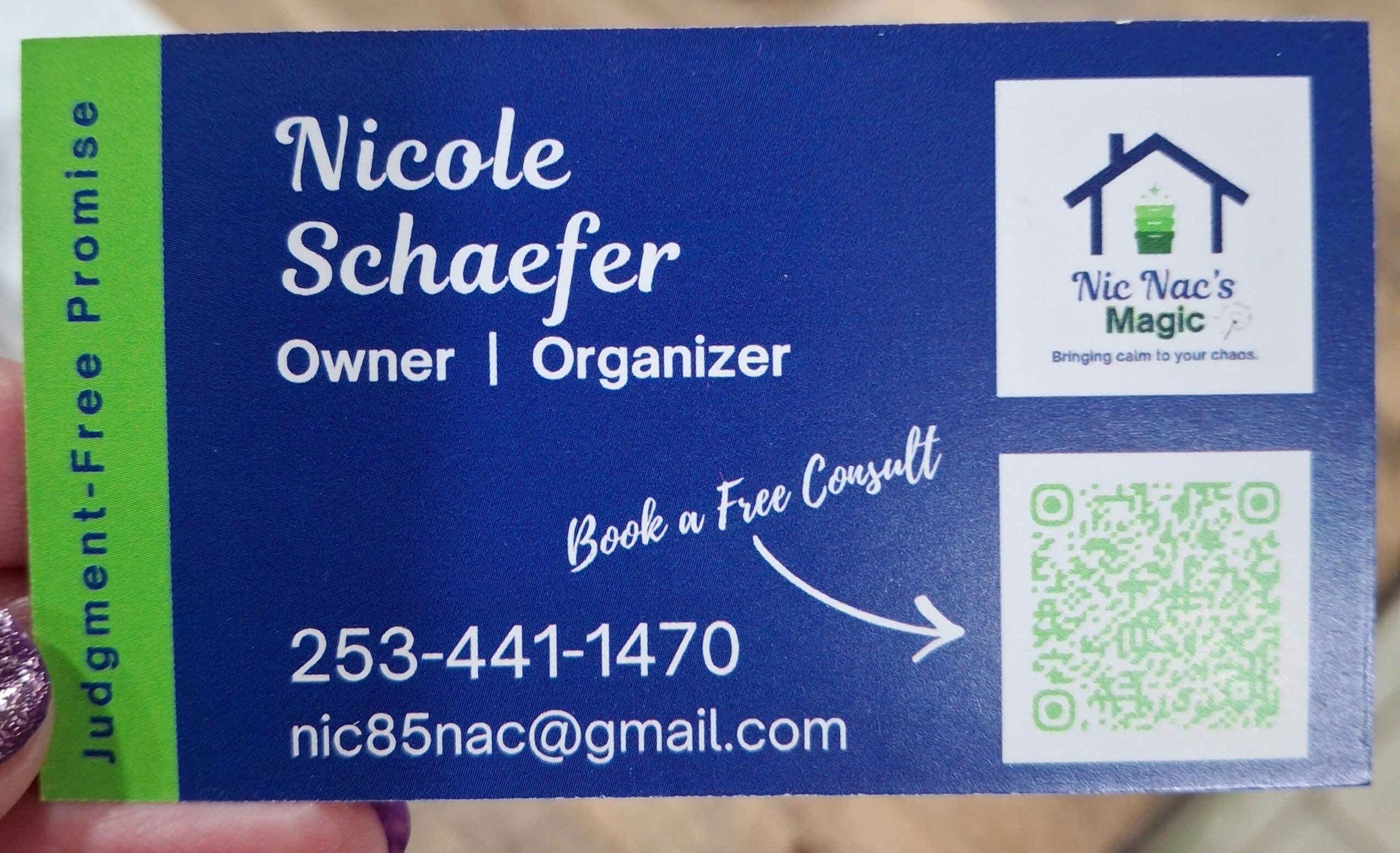 Business card with blue background, white text, and a house logo, displaying name, contact info, and a QR code.