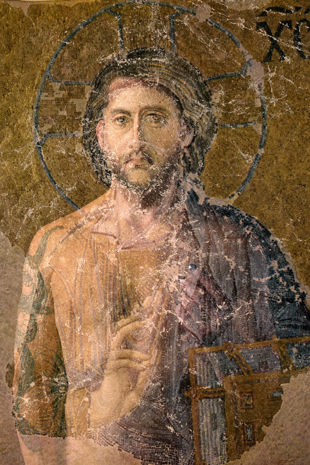 A religious icon depicting Jesus Christ with a halo, holding a book and making a blessing gesture.